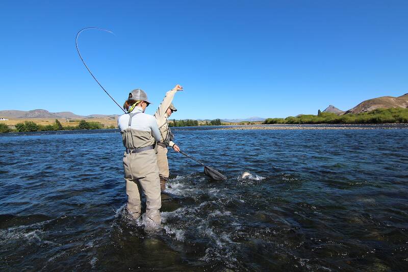 I love this shot of my wife landing a bruiser rainbow (trucha arcoiris locally) on the mighty Chimeuin River